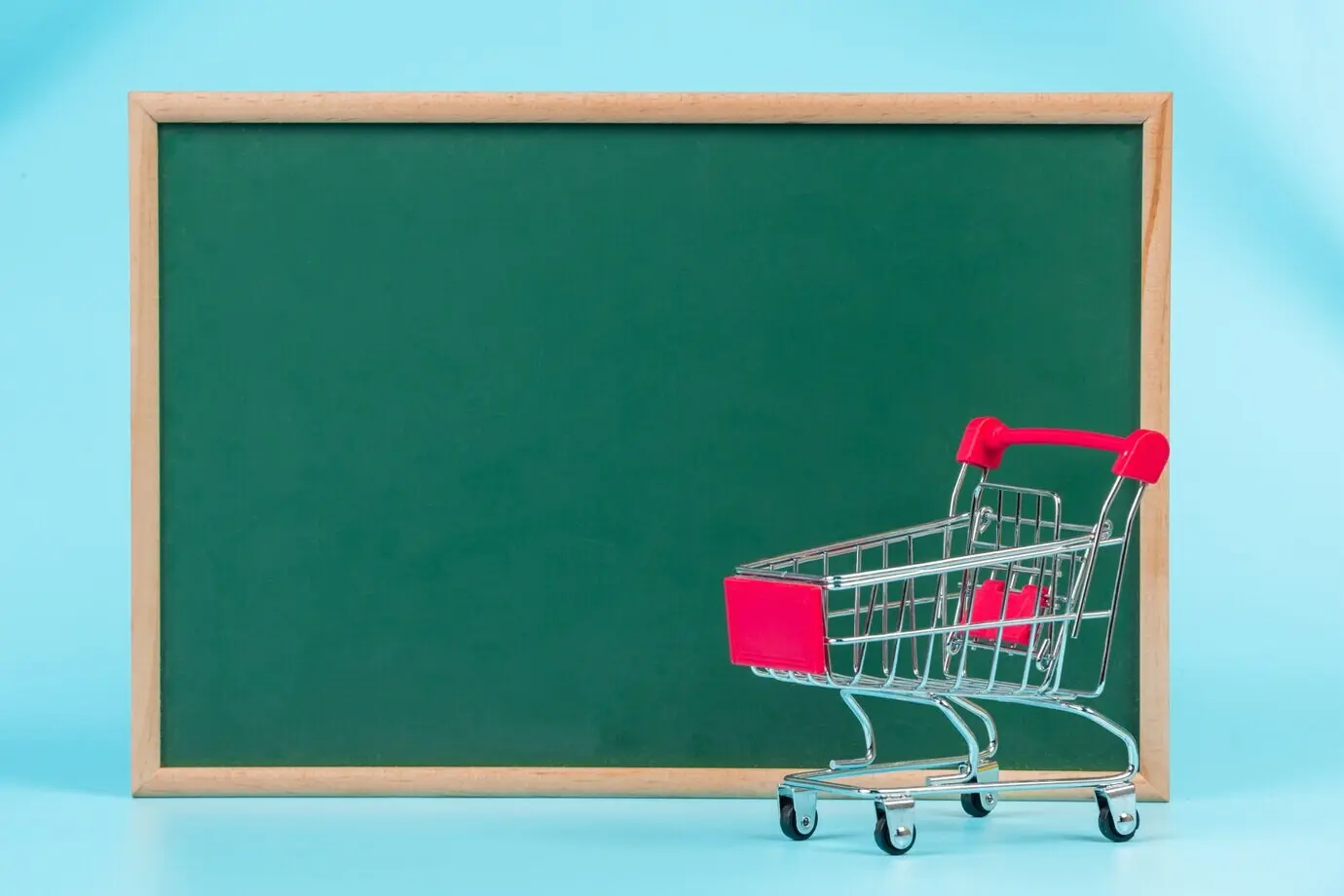 Online shopping: a double cart positioned on a green board on a blue.